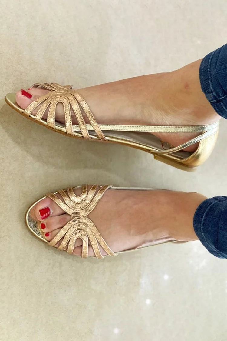 Sandalias doradas con tiras decorativas en forma de abanico y punta abierta, tacón bajo.