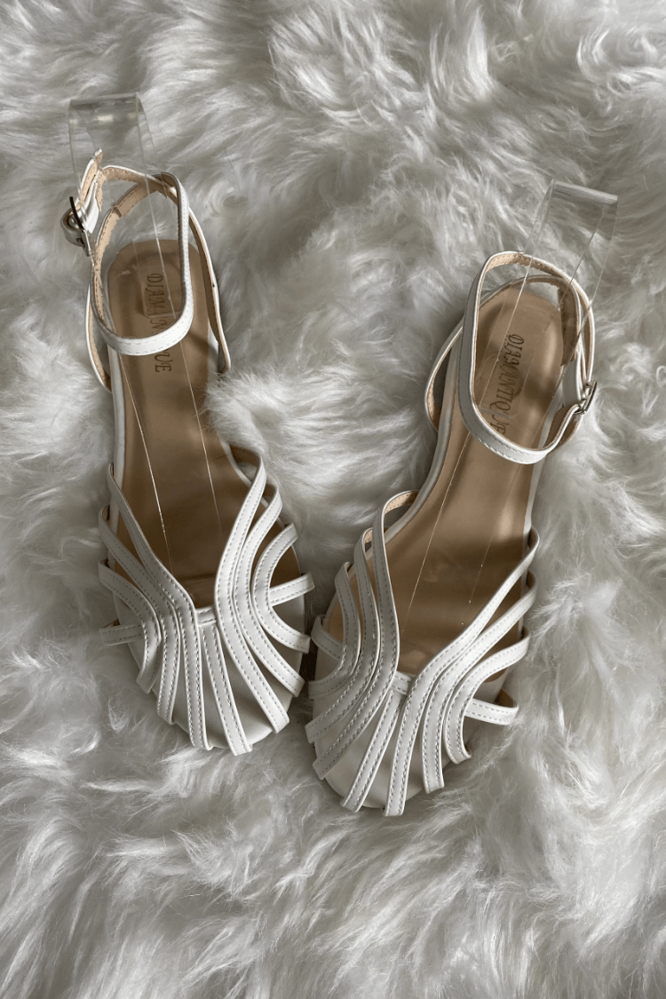 Sandalias blancas de tiras con diseño entrelazado y pulsera ajustable, suela plana.