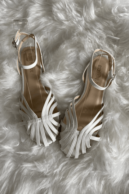 Sandalias blancas de tiras con diseño entrelazado y pulsera ajustable, suela plana.