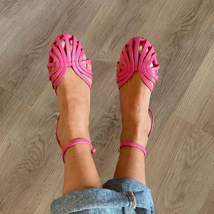 Sandalias fucsia con tiras trenzadas en la parte delantera y pulsera al tobillo.