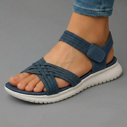 Sandalias ortopédicas azules con tira cruzada elástica y suela acolchada blanca