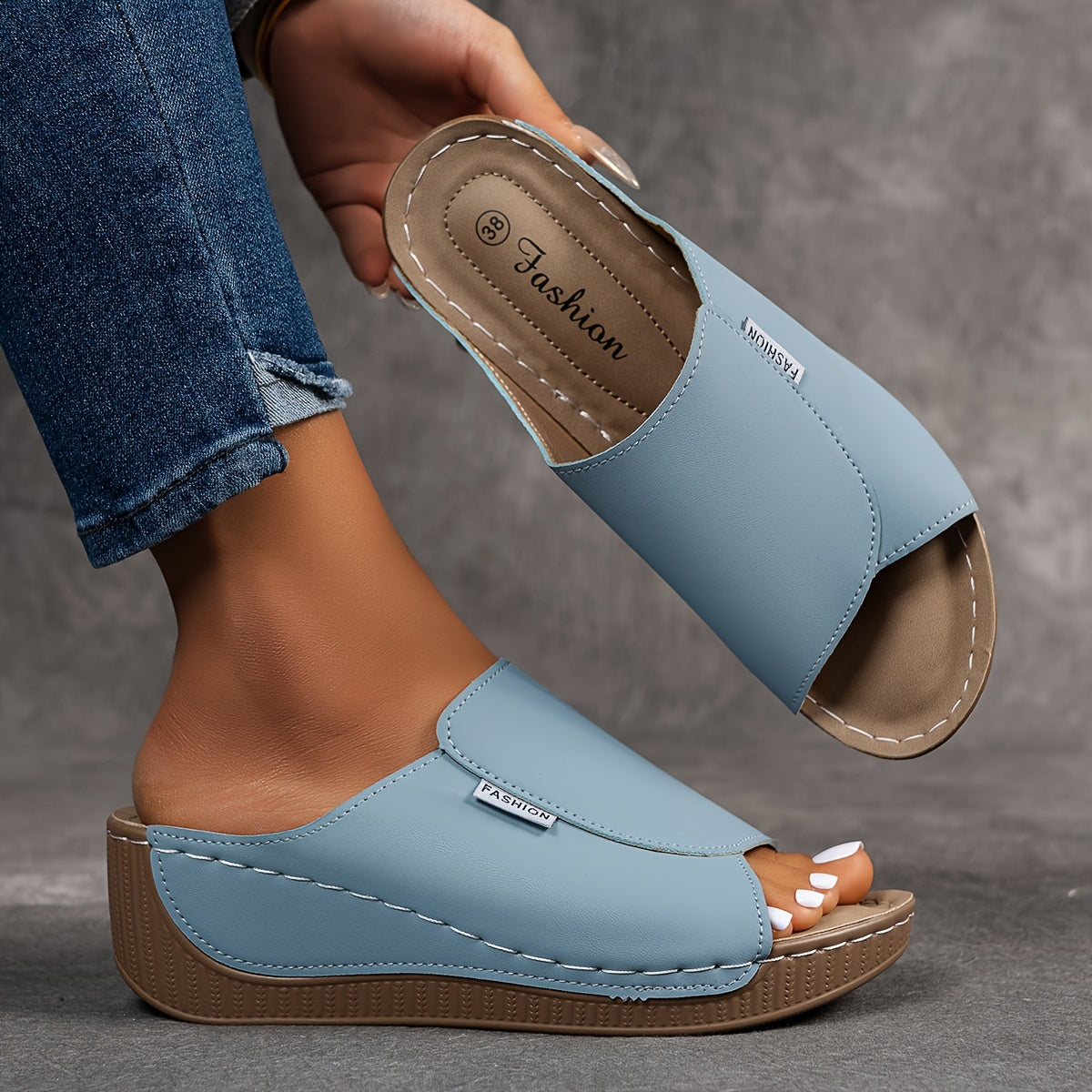 Sandalias tipo zueco con arco plantar, azul claro, suela de cuña marrón y costuras a la vista