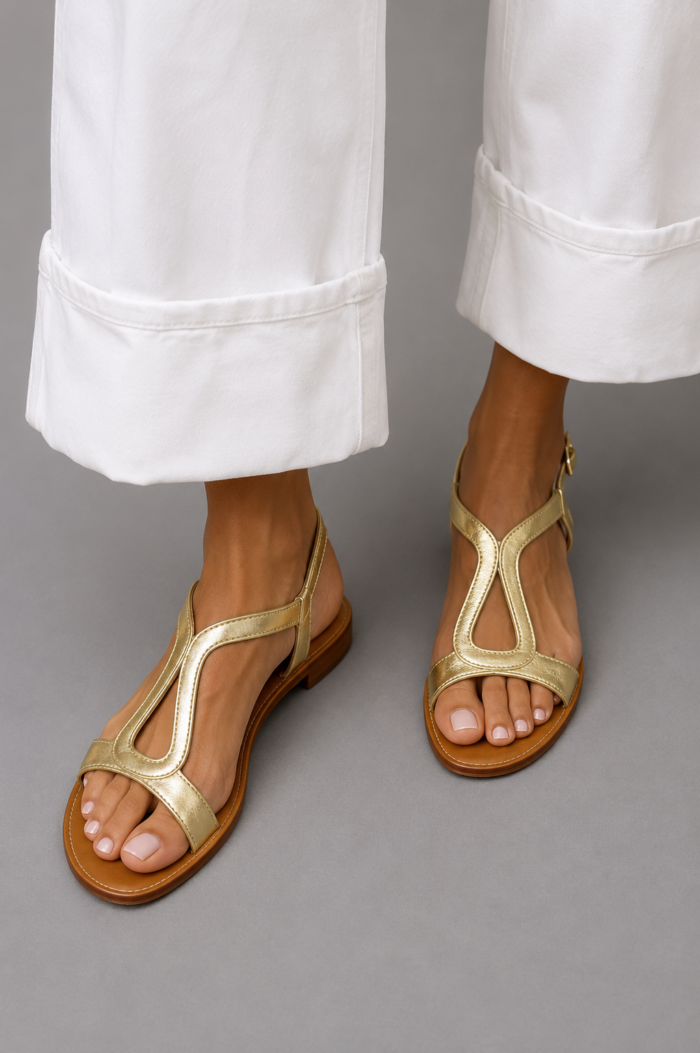 Sandalias de dedo doradas con tiras y suela marrón, acabado metalizado