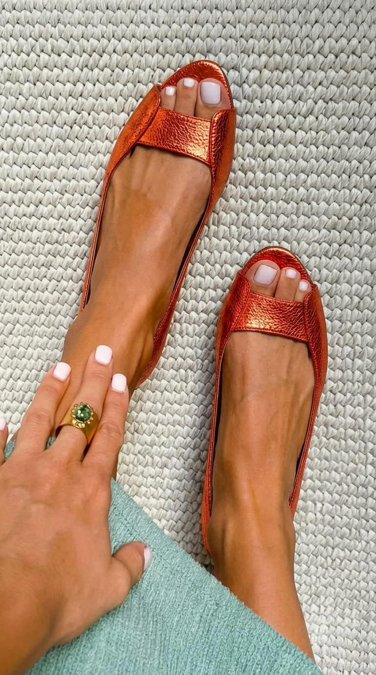 Sandalias planas tipo pala naranja con tira frontal y acabado metalizado