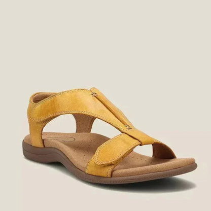 Sandalia ortopédica ergonómica amarilla de piel, con tiras anchas y suela marrón.