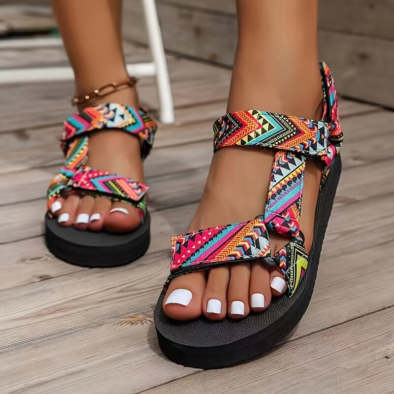 Sandalias ortopédicas multicolor con tiras cruzadas, pulsera dorada y suela negra gruesa.