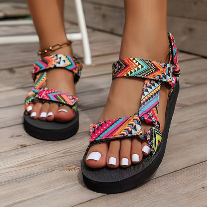 Sandalias ortopédicas multicolor con tiras cruzadas, pulsera dorada y suela negra gruesa.