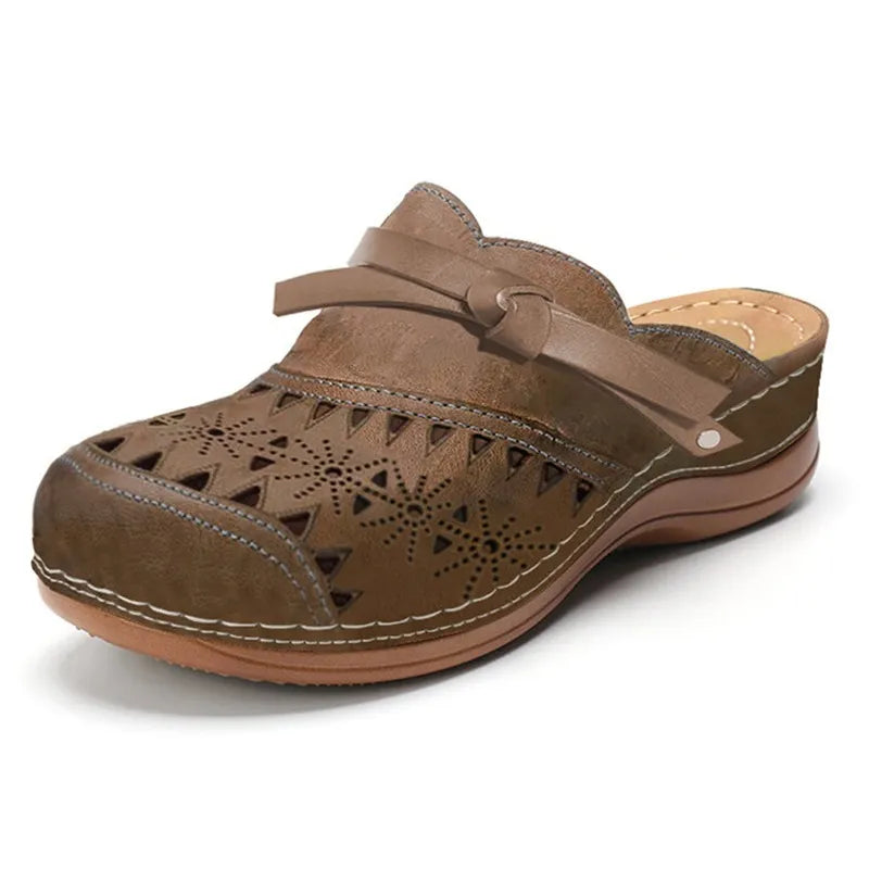 Zueco ortopédico marrón con perforaciones, tira ajustable y suela de cuña marrón