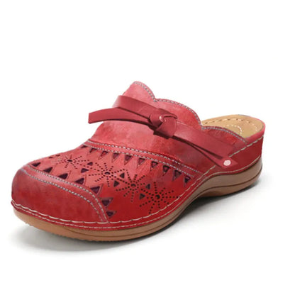 Zueco ortopédico rojo con perforaciones, tira ajustable y suela de cuña marrón