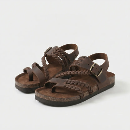 Sandalias anatómicas marrón oscuro con trenzado y hebilla metálica ajustable.