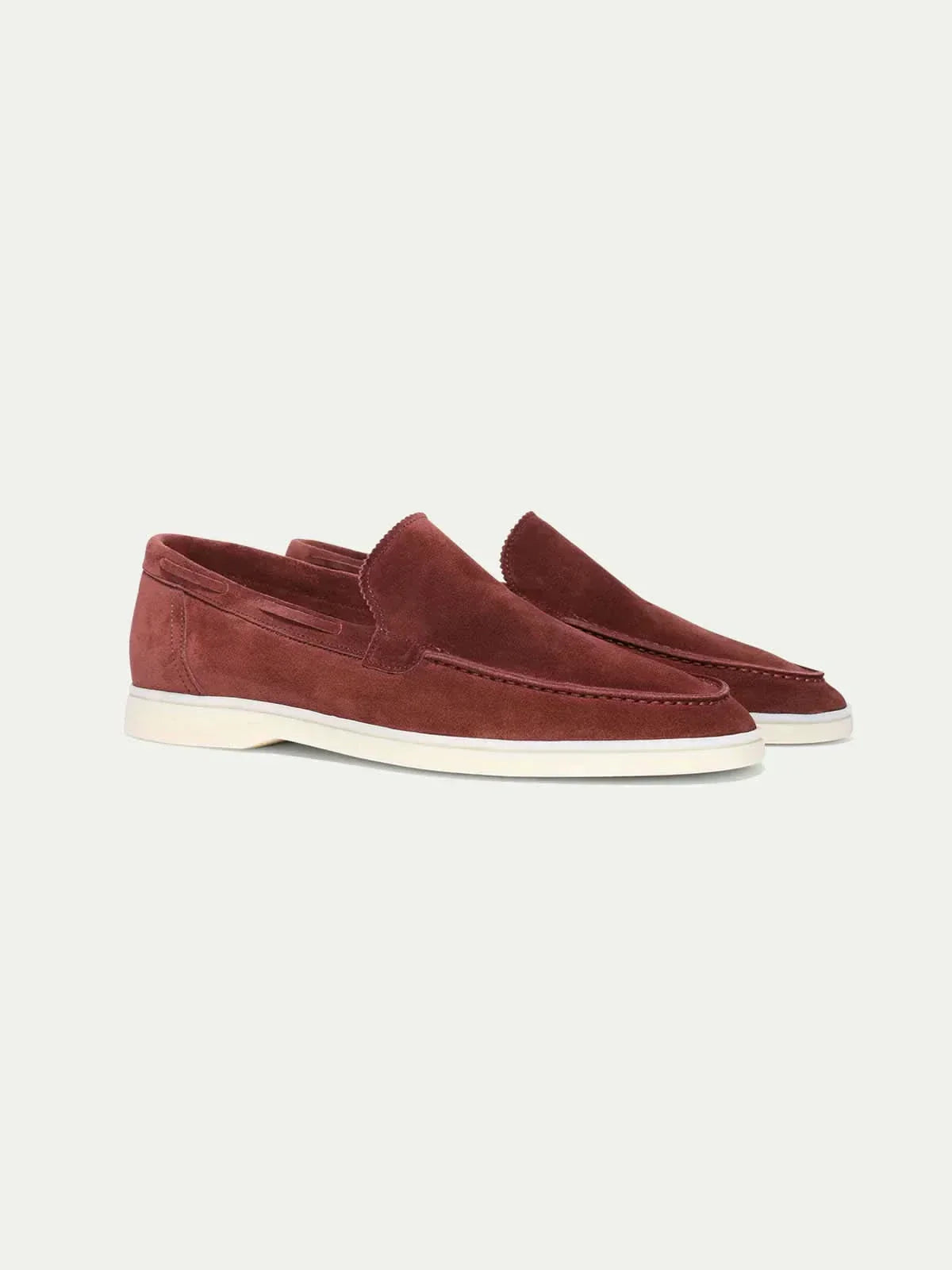 Mocasines de ante caramelo rojizo, slip-on, con suela blanca.