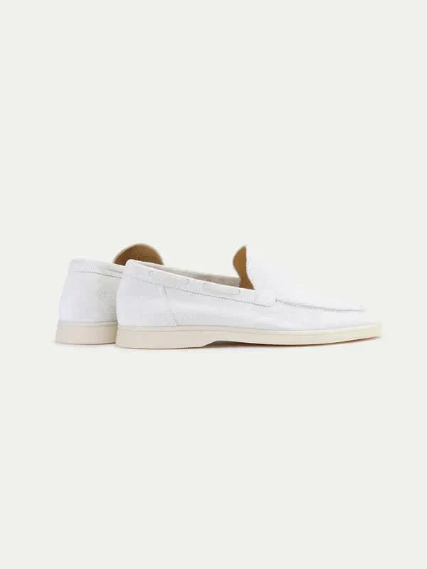 Mocasín de ante blanco con suela blanca, pala lisa y talón descubierto.