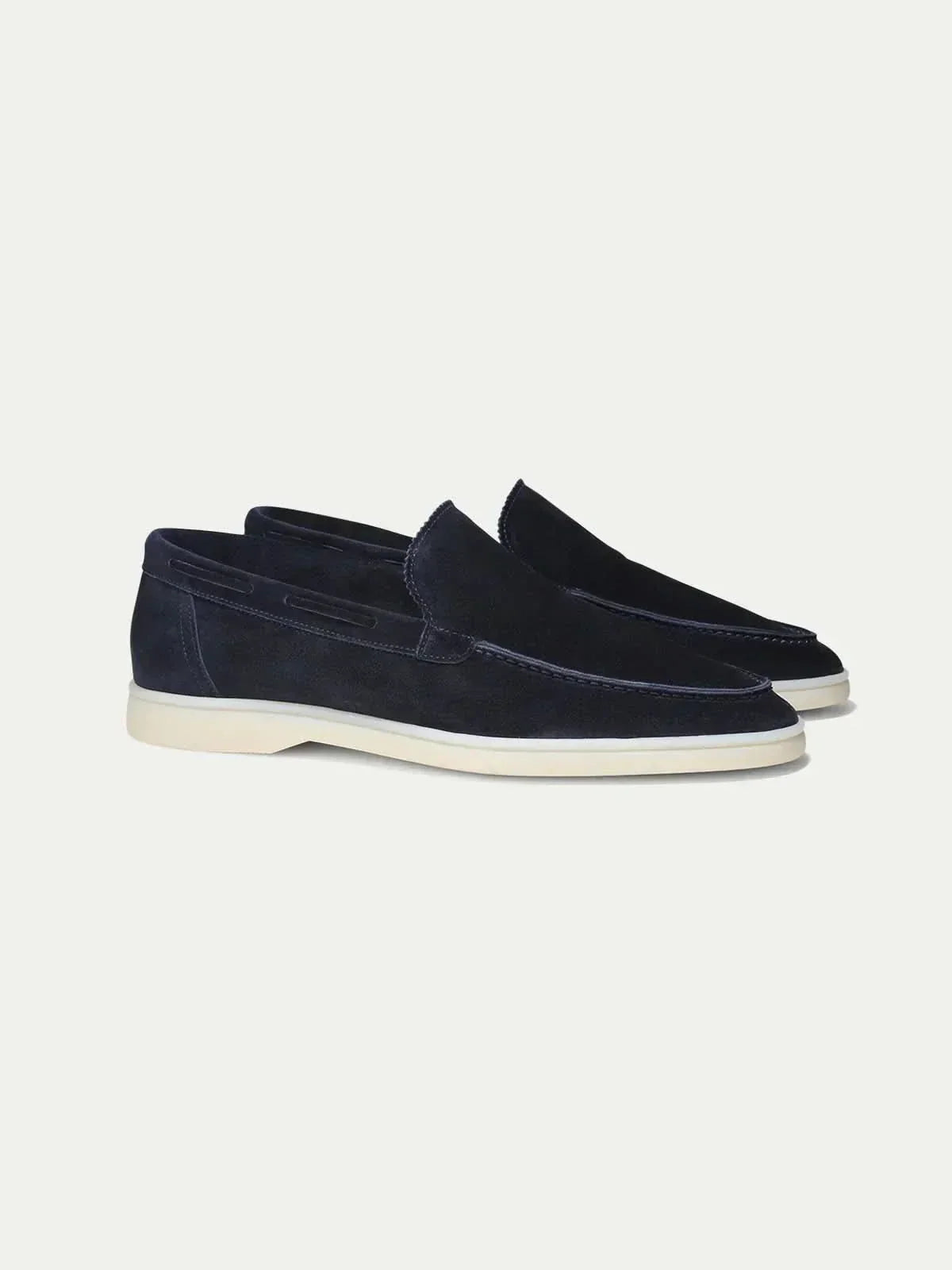 Mocasines de ante azul marino, slip-on, con suela blanca.