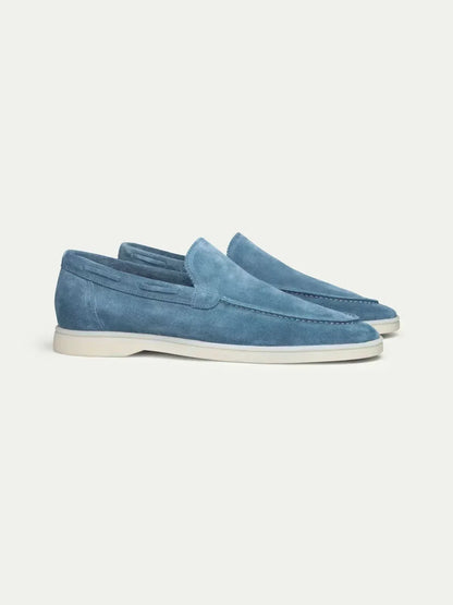 Mocasín de ante azul con suela blanca, plantilla corrida y detalle de costuras.