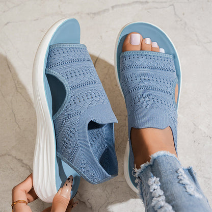 Sandalias ortopédicas de tejido azul claro en pies, punta abierta y suela blanca acolchada