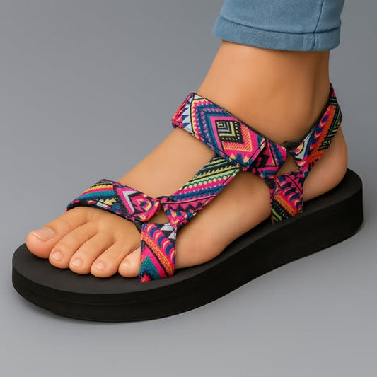 Sandalias ortopédicas negras con tiras cruzadas y estampado azteca multicolor.