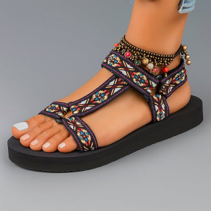 Sandalias ortopédicas con tiras multicolor y adorno de cuentas en el tobillo.